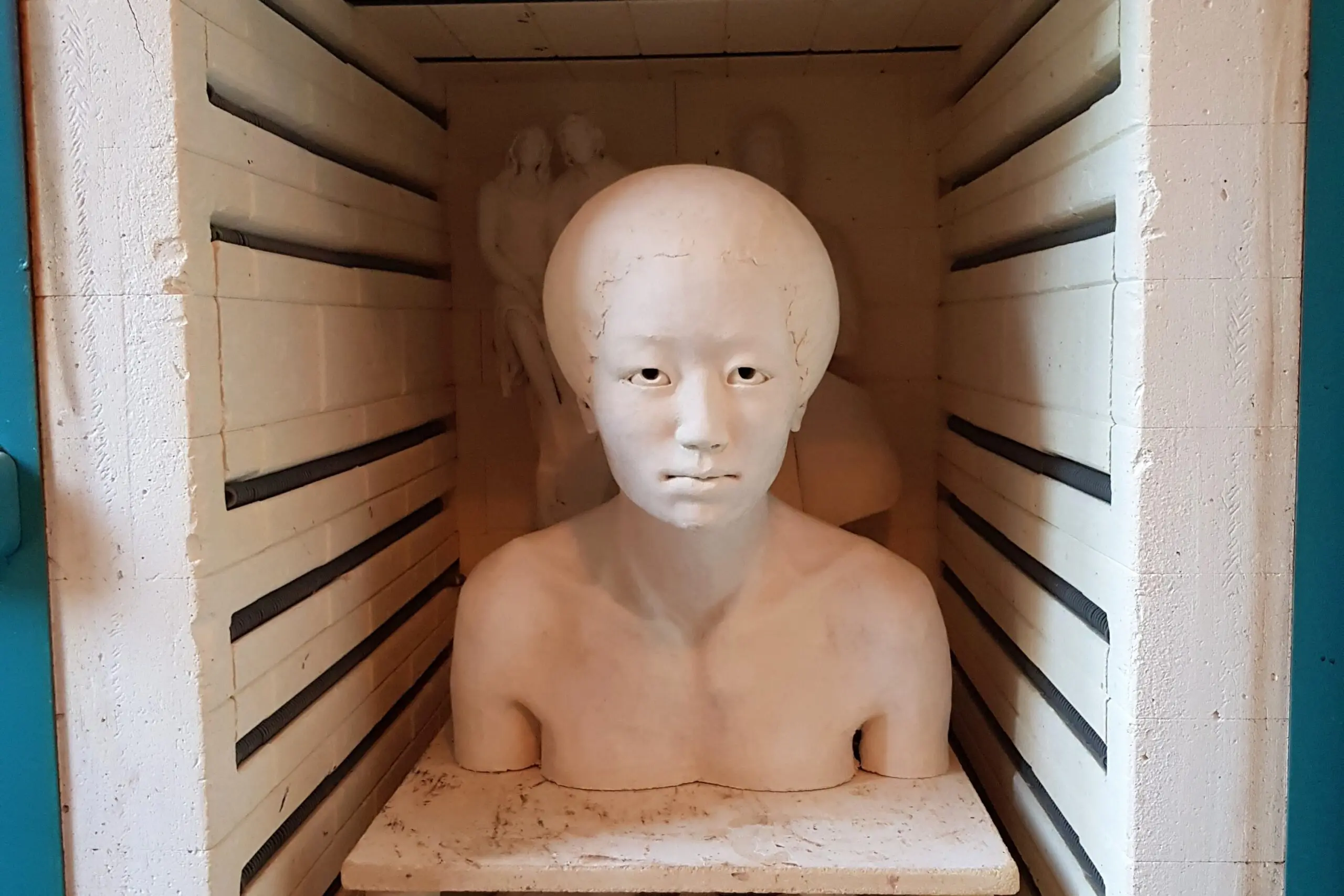 Buste en céramique dans un four de cuisson.