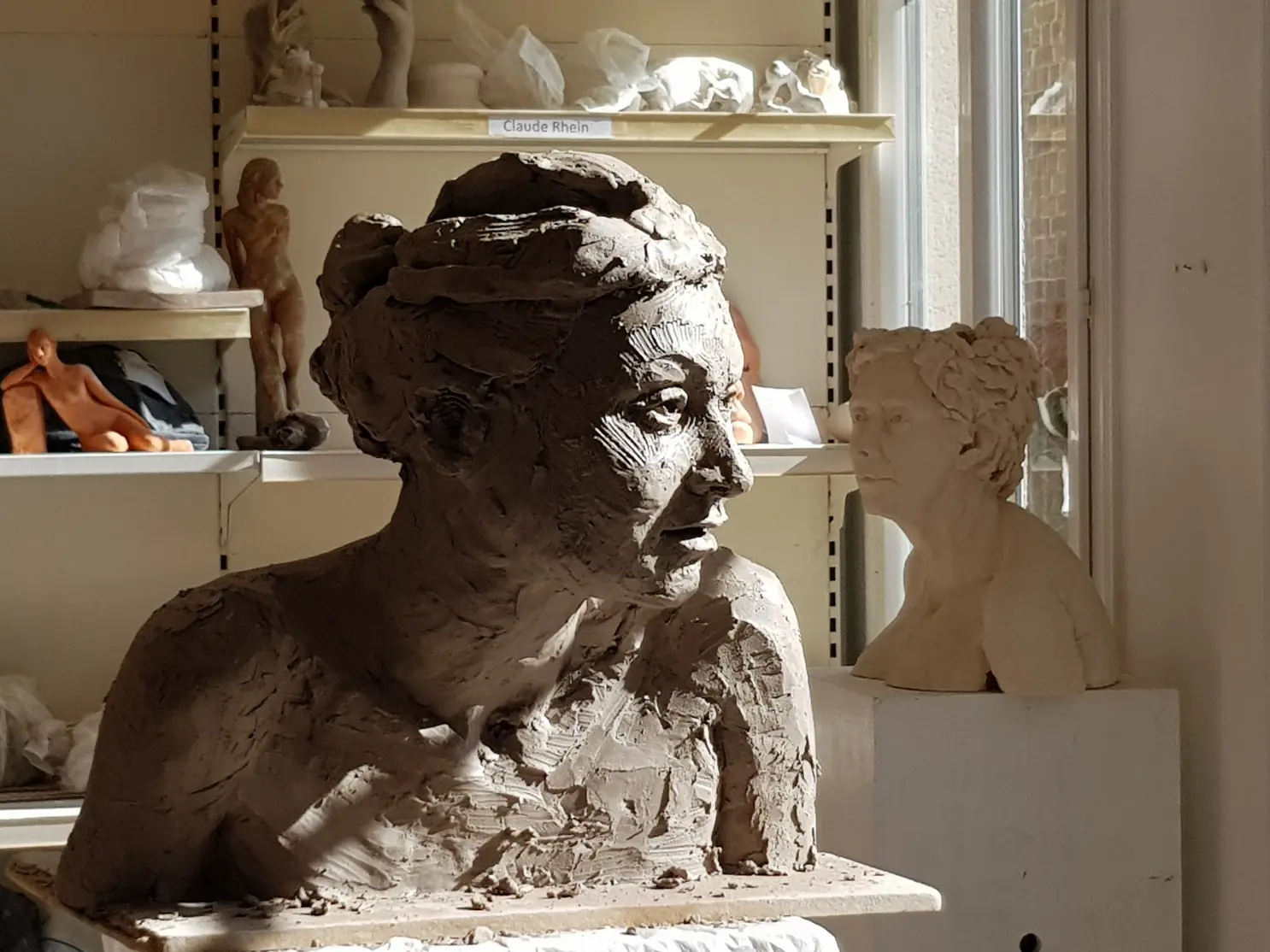 Bustes en argile dans un atelier lumineux.
